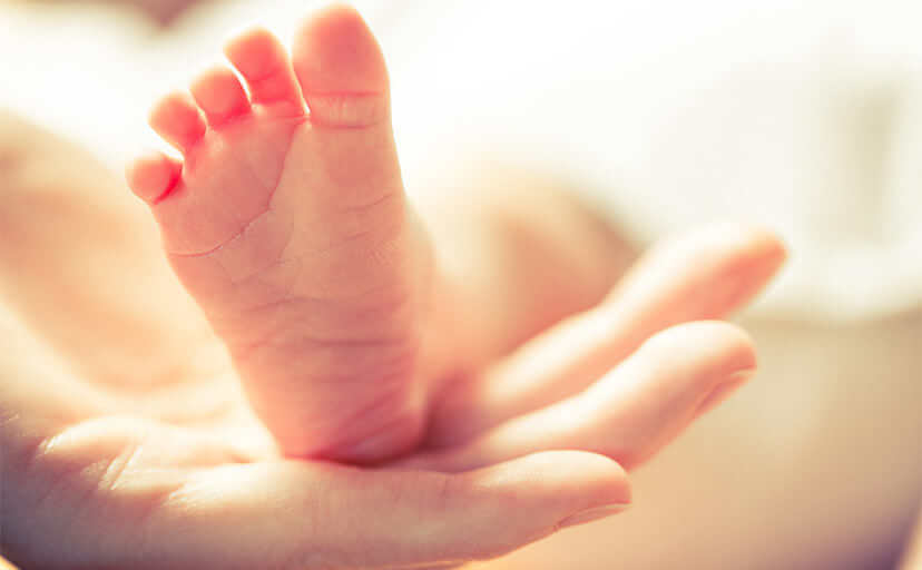 赤ちゃんの足を持つ手（フリー写真）