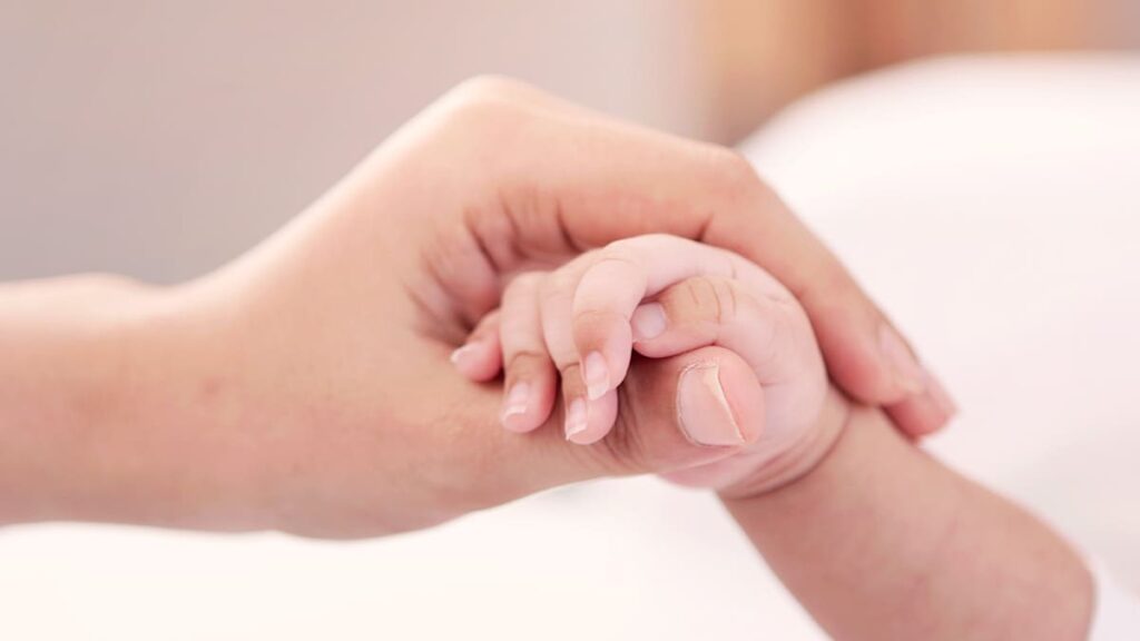 赤ちゃんの手を握る母（フリー写真）